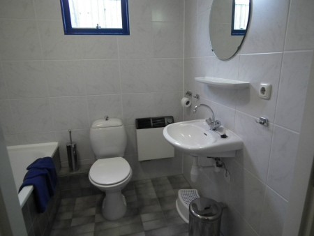 Badkamer met douche, ligbad, wastafel en toilet